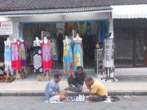 Men defying the traffic to play chess on the road in Seminyak
